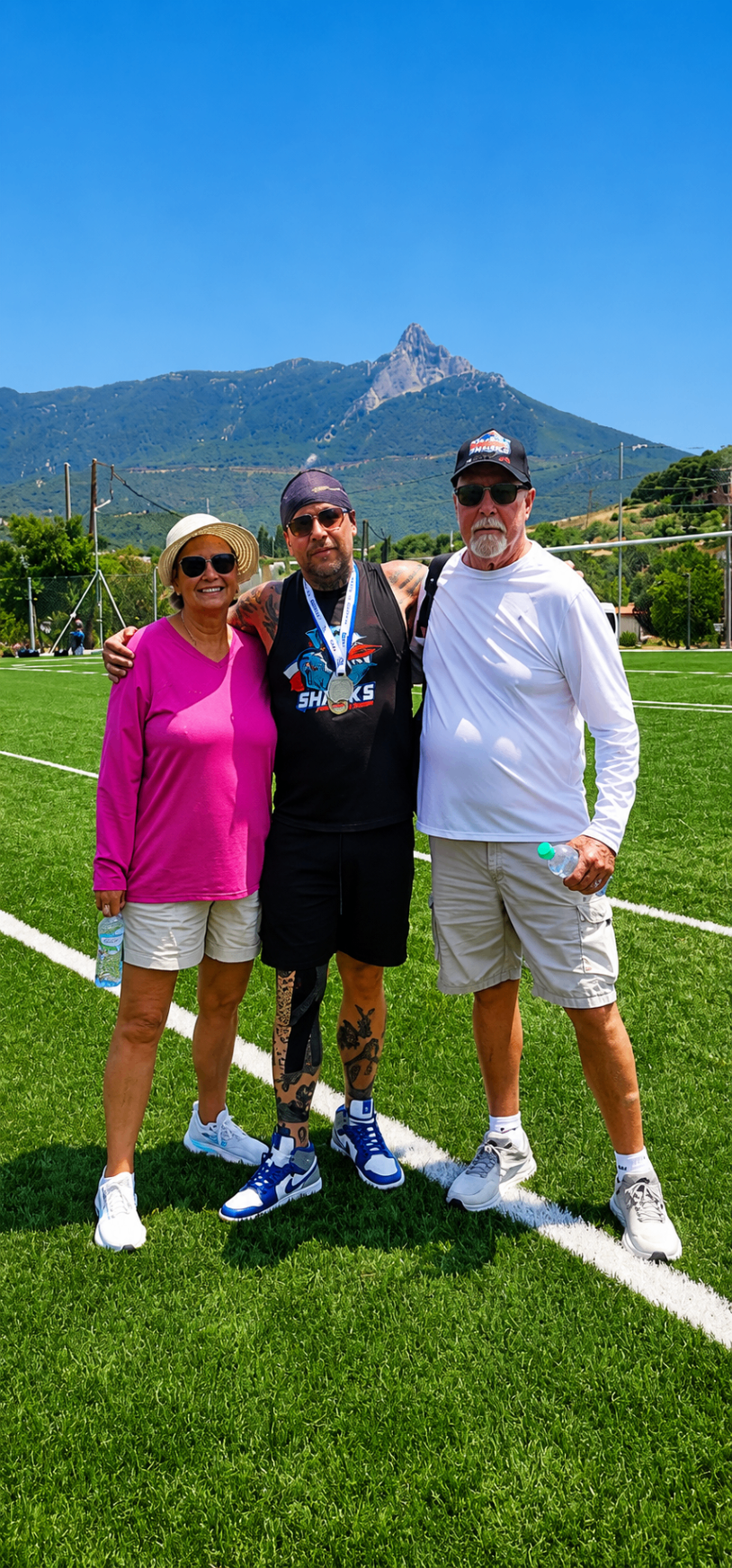 Ian with two supporters beneath the Greek mountains