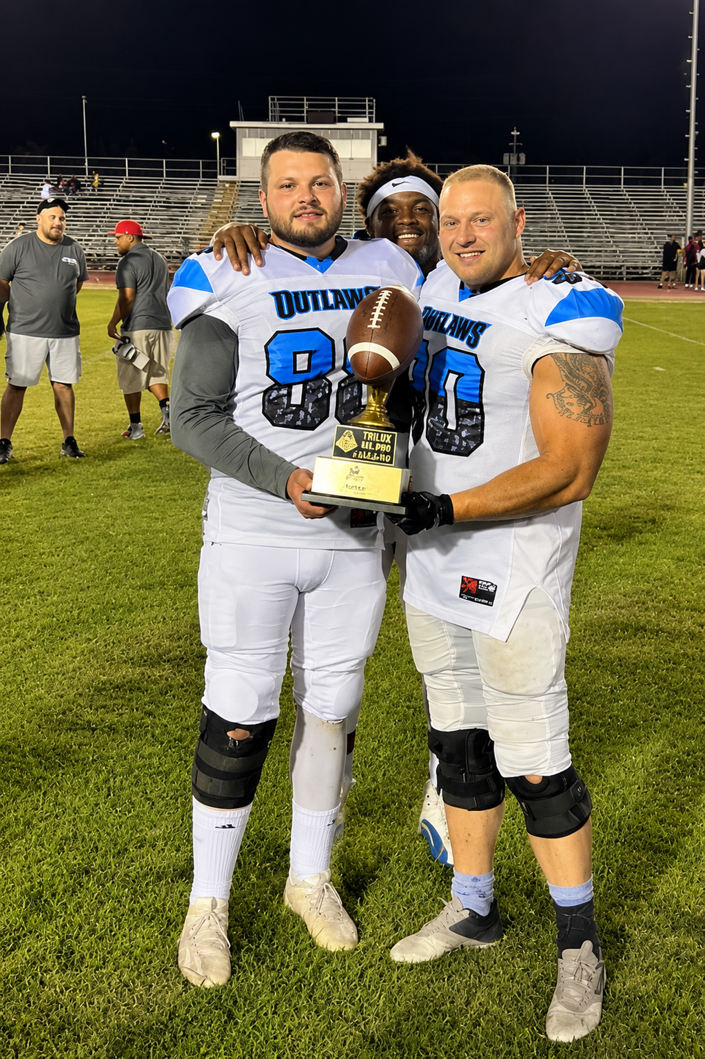 Three Phoenix Outlaws teammates together with the championship trophy