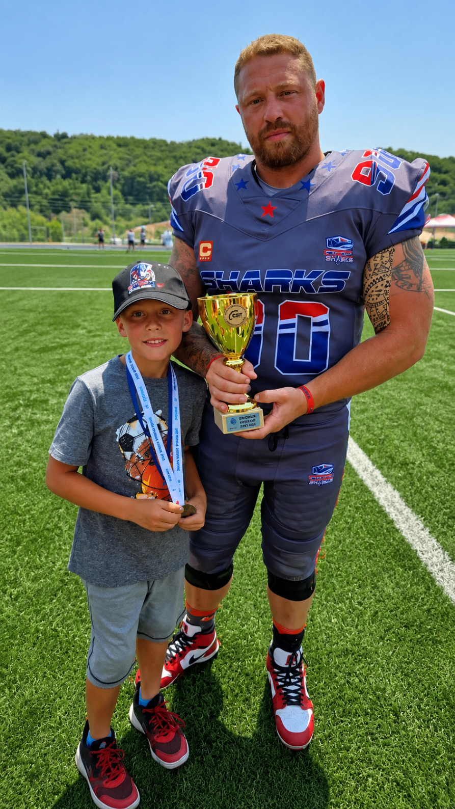 Karl and a young supporter holding the Greece championship trophy