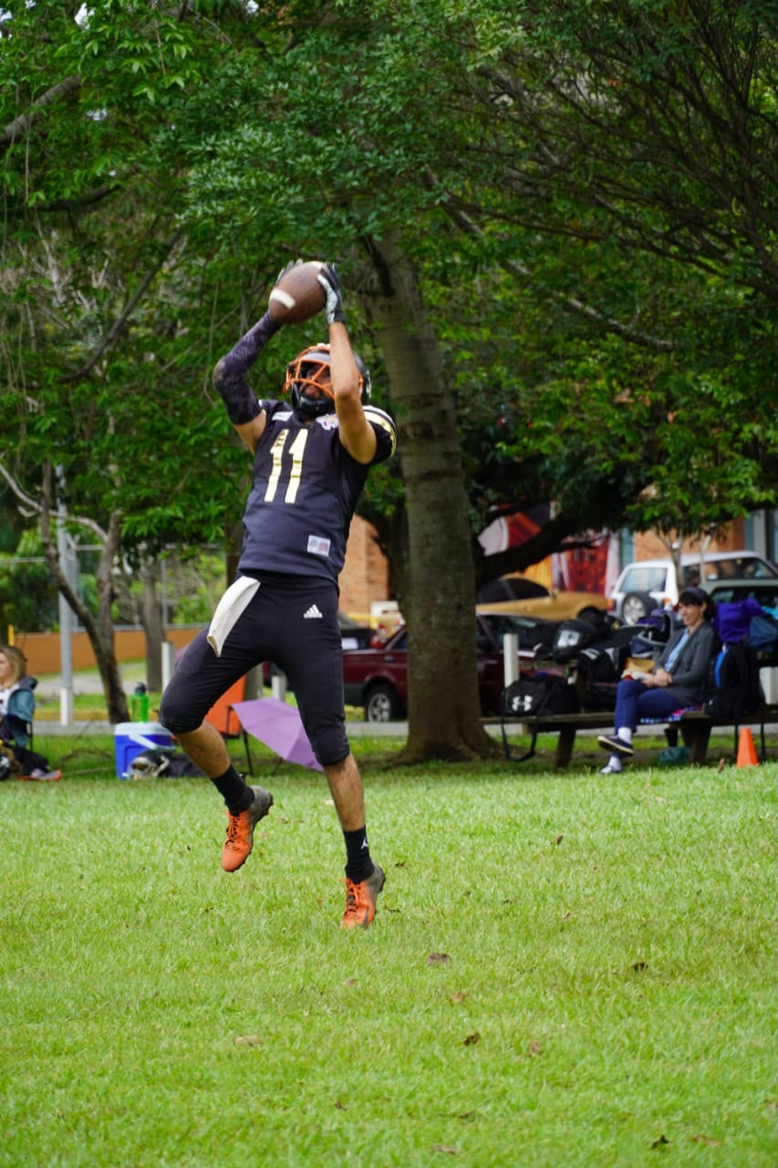 Alajuela Pumas player leaping to catch the football